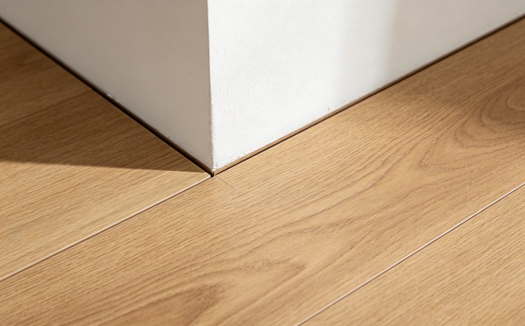 SPC flooring installation with visible expansion gap along wall