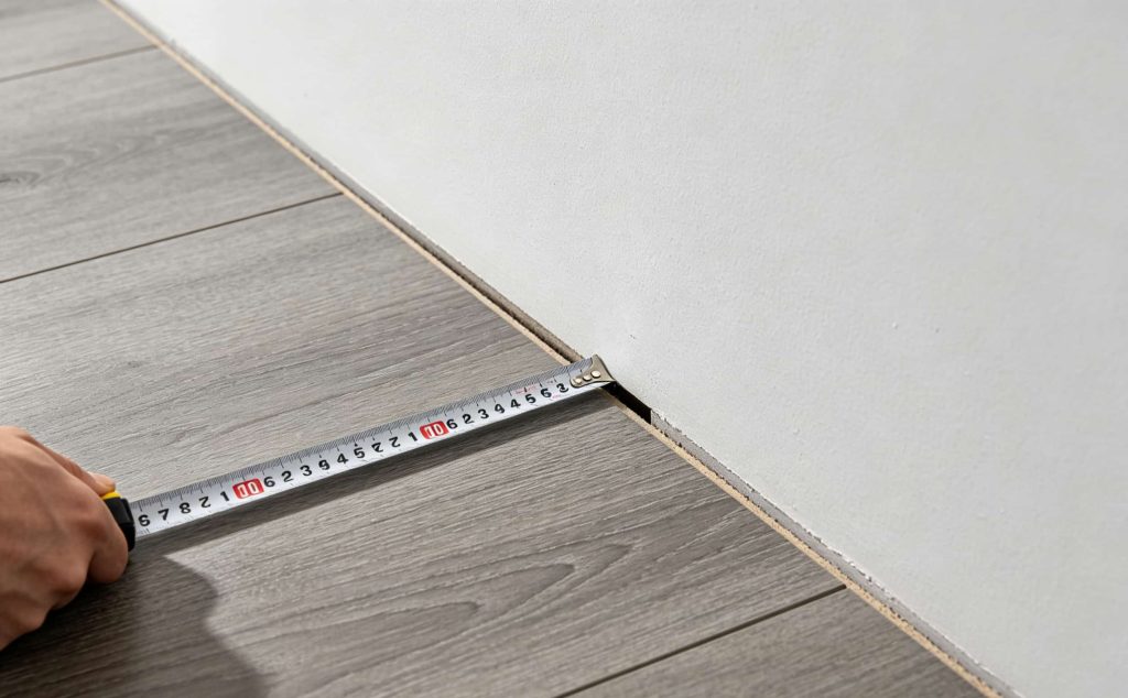 measuring expansion gap for SPC flooring installation with tape measure